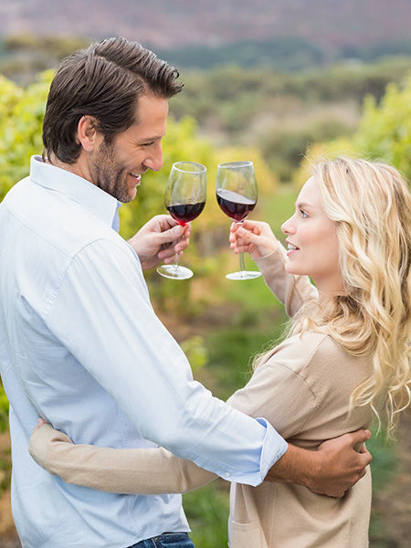 Young happy couple toasting in the grape fields